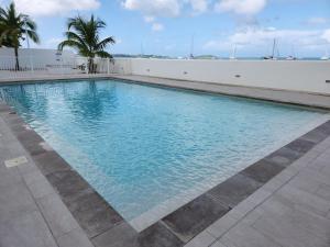 - une piscine avec vue sur l'eau dans l'établissement Beau duplex vue mer avec piscine et accès plage, à Saint-Martin
