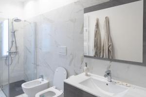 ein Badezimmer mit einem Waschbecken, einem WC und einem Spiegel in der Unterkunft Casa Medici in Asti