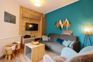 a living room with a couch and a tv at Komfort-Fewo Schöner Platz am Rathaus in Willingen