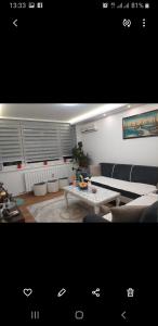 - un salon avec un canapé et une table dans l'établissement Trosoban apartman Sarajevo, Ilidza centar, à Sarajevo