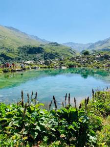 a lake in the mountains with people standing around it at Cosy Montagne in Valmeinier