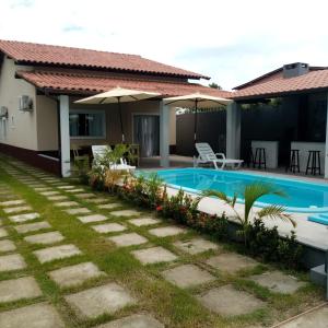 een villa met een zwembad en een huis bij Casa individual com piscina e area gurmet in Santa Cruz Cabrália