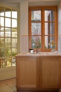 a kitchen with a sink and two windows at Bienvenue en terre écossaise in Aubigny-sur-Nère