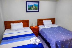 dos camas sentadas una al lado de la otra en una habitación en Hotel Los Andes Boutique, en Huaraz