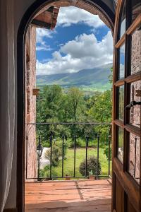 uma janela arqueada com vista para um campo em Castillo de Piedra Tafi del Valle em Tafí del Valle