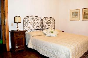 a bedroom with a bed and a lamp and a table at Casa Rosa in Pescasseroli