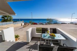 un tavolo e sedie su un balcone con vista sulla spiaggia di On The Beach a Ierápetra