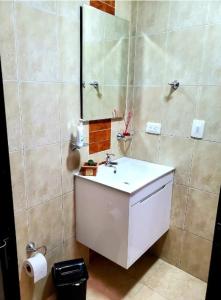 y baño con lavabo blanco y espejo. en Espléndido apto completo en el centro de Pereira, en Pereira