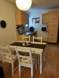 Apartment Entegast في شوبفهايم: مطبخ مع طاولة وكراسي في مطبخ