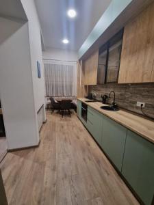 a kitchen with wooden floors and cabinets and a sink at Nino's Cosy Apartment in Kutaisi