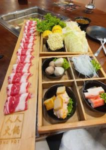 a table topped with three trays of sushi and vegetables at Serenity Cove MOA in Manila