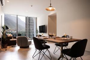 a dining room with a table and chairs with a view at 5 min de UDEM, moderno, lujoso en Jardín Secreto 810 in Monterrey
