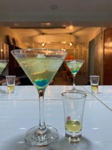 two martini glasses sitting on a white table with at Hotel Los Andes Boutique in Huaraz