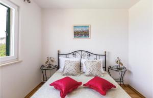 1 dormitorio con 1 cama con 2 almohadas rojas en 4 Bedroom Stunning Home In Tucepi, en Tučepi