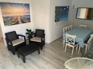 un soggiorno con tavolo, sedie, tavolo e sedie di ORANGE guest house a Sagres