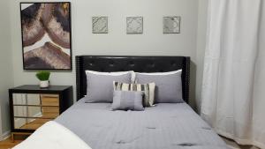 a bedroom with a bed with a black headboard and pillows at Room for rent in apartment Hartford, CT in Hartford