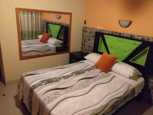 Un dormitorio con dos camas y un gran espejo. en Paradisse, en Huacho