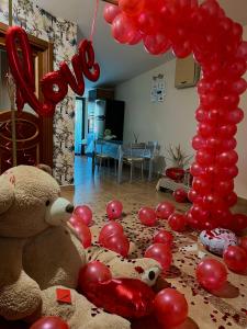 una habitación con un montón de globos rojos y un osito de peluche en Valentino Bed And Breakfast, en Capodrise