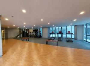an empty gym with a wooden floor and glass windows at The Florence at McKinley Hill in Manila