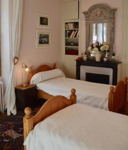 a bedroom with two beds and a fireplace at Bienvenue en terre écossaise in Aubigny-sur-Nère