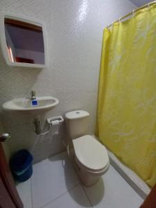 a bathroom with a white toilet and a sink at Hotel CHAFO in Leticia