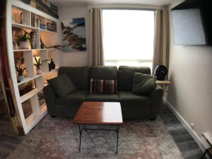 a living room with a couch and a coffee table at Sporty Mountain & Lake View 3rd Floor Studio in Big Sky