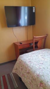 a bedroom with a bed and a tv on the wall at Big Attico in Puerto Montt