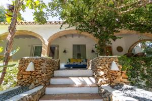uma casa com uma parede de pedra e escadas em frente em Casa Algarrobo em Xàbia