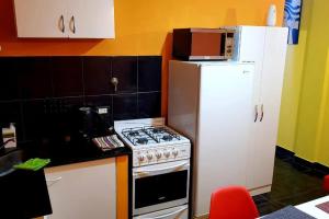 een keuken met een fornuis en een witte koelkast bij Departamento moderno x día in Neuquén