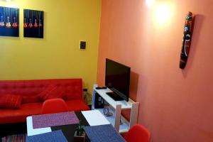 een woonkamer met een rode bank en een flatscreen-tv bij Departamento moderno x día in Neuquén