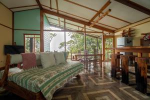 1 dormitorio con 1 cama en una habitación con ventanas en Above the Gulf, Vacation House, en Monteverde