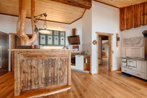 una grande cucina con pavimenti in legno e soffitti in legno di Apartment Eckstoa ad Abtenau