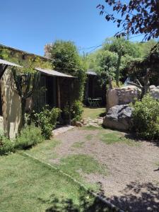 un jardín con una casa y un patio con césped en Casitas del Cerro en Chacras de Coria