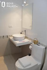 La salle de bains blanche est pourvue d'un lavabo et de toilettes. dans l'établissement Hotel Qoya Palace - Machupicchu, à Machu Picchu