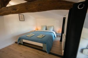 a bedroom with a bed with blue sheets and two towels at La maison à Mimine in Le Pin-en-Mauges