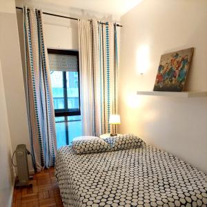 een slaapkamer met een bed voor een raam bij Trindade Apartment in Porto