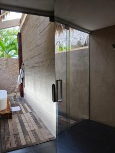 d'une porte vitrée donnant sur une salle de bains pourvue d'une douche. dans l'établissement Isla Tajín, à Tuxpan