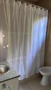 łazienka z zasłoną prysznicową i umywalką w obiekcie Cabaña Patagónica w mieście El Calafate