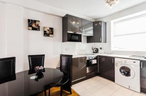 a kitchen with a table and a washing machine at Parnell Apartments in Dublin +17 photos