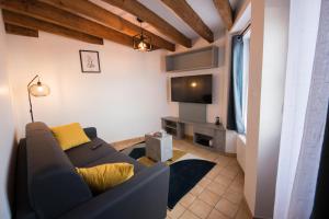 ein Wohnzimmer mit einem Sofa und einem TV in der Unterkunft La maison à Mimine in Le Pin-en-Mauges