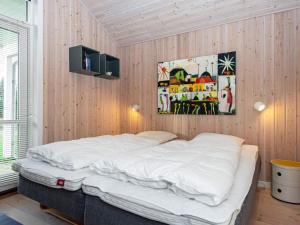 un letto in una camera con pareti rivestite in legno di Three-Bedroom Holiday home in Ulfborg 16 a Fjand Gårde