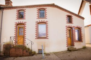 una antigua casa blanca con escaleras y ventanas en La maison à Mimine en Le Pin-en-Mauges