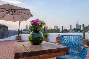 un vase rempli de fleurs assis sur une table dans l'établissement NaNa Vida CDMX, à Mexico