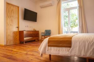 a bedroom with a bed and a dresser and a window at NaNa Vida CDMX in Mexico City