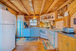 a kitchen with blue cabinets and a white refrigerator at Wood Road Retreat in Quechee +10 photos