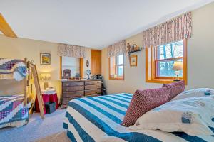 a bedroom with a bed and a dresser and a window at Wood Road Retreat in Quechee