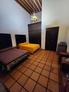 een kamer met 2 bedden op een tegelvloer bij Casa monarca in Morelia