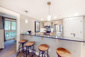 a kitchen with bar stools and a counter top at Baytowne Wharf - Observation Point North #351 in Destin