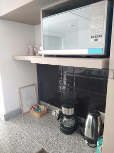 un microondas sobre una barra de cocina con cafetera en Zona Güemes departamento nuevo en Mar del Plata