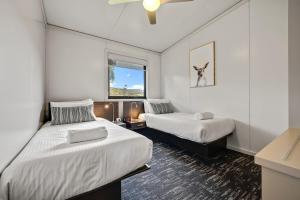 ein Hotelzimmer mit 2 Betten und einem Fenster in der Unterkunft Ecocrackenback 3 Sustainable chalet close to the slopes in Crackenback
